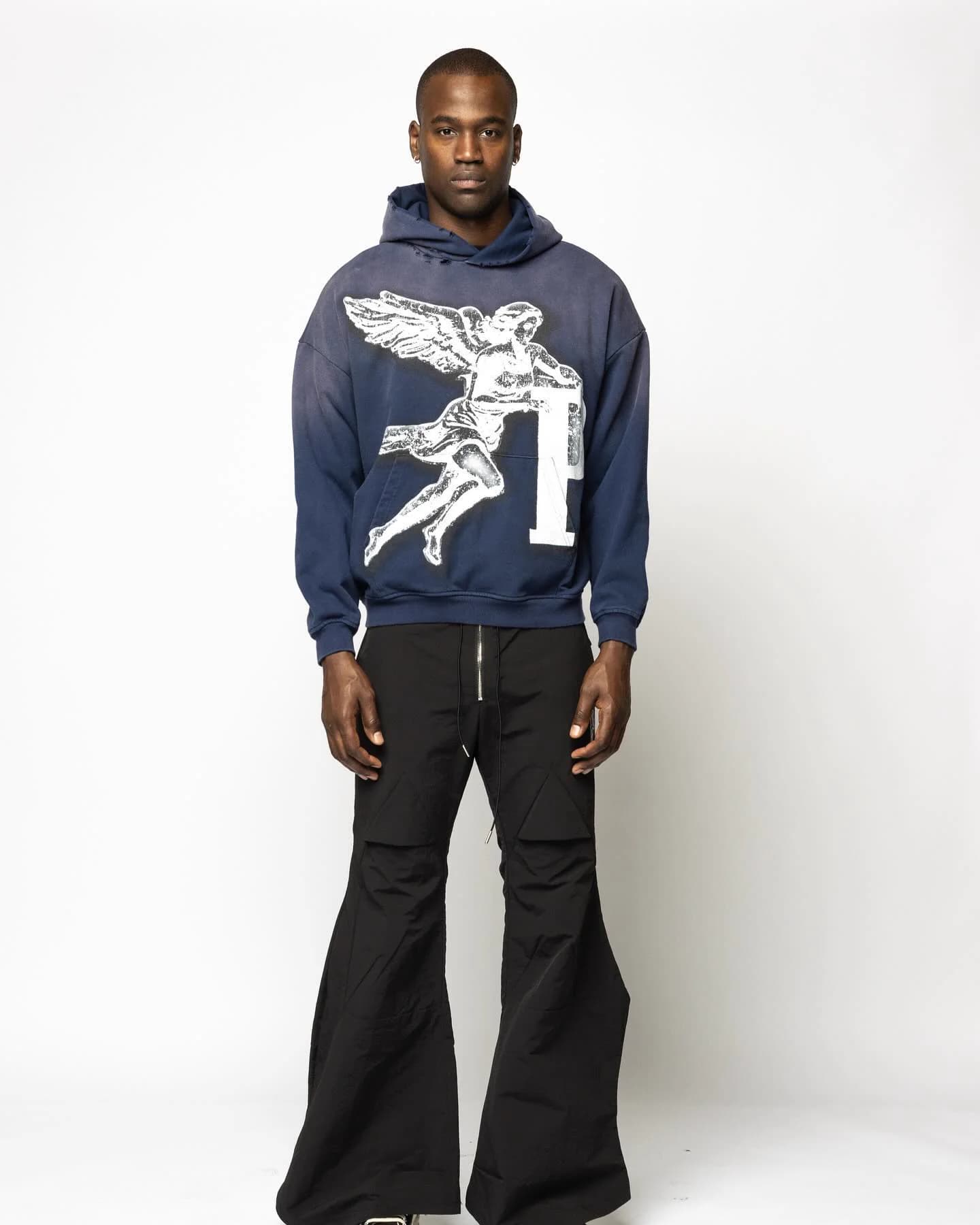 Model wearing a navy PSRVE hoodie with angel artwork